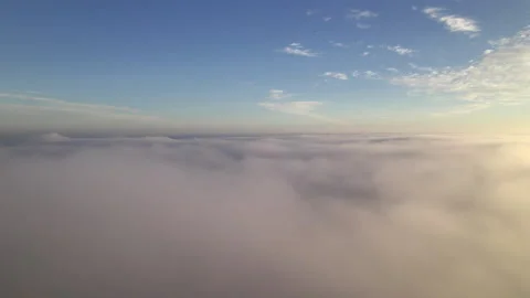 High fast tracking aerial drone shot through clouds with sunset Stock Footage 154128716