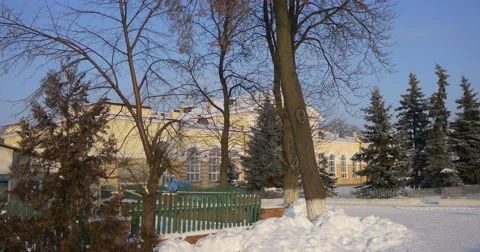 High Fir Trees Standing Before an Impressive Railway Station Building in Stock Footage 59003082