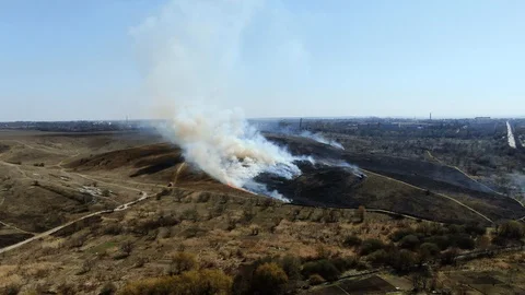High fire in an empty field near the city. Strong smoke from burning place. Stock Footage 128108374
