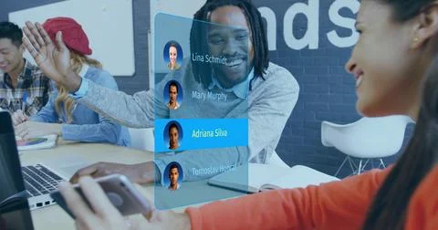 High-fiving man with dreadlocks, reaching woman in orange-top at long table, Stock Photos