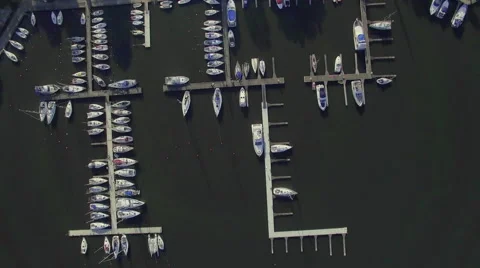 A high fly-over looking straight down at a small marina on a european lake Video stock 63920156
