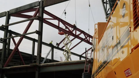 High Flying Construction Workers Installing Large Steel Beam 4K 48FPS SLO-MO Stock Footage 265803814