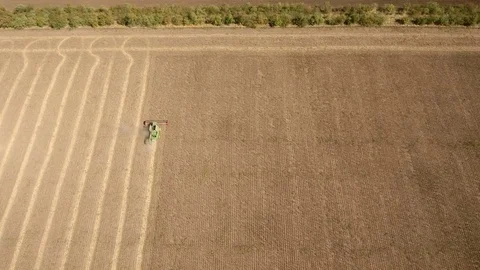 A high flying drone flies after of a combine harvester collecting sunflower. Stock-Footage 82473129