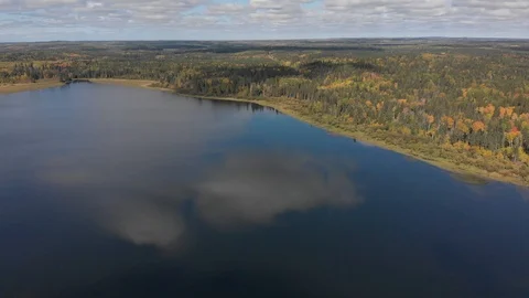 High flying drone over a lake calm lake with white clouds reflecting in the lake Stock Footage 116732171