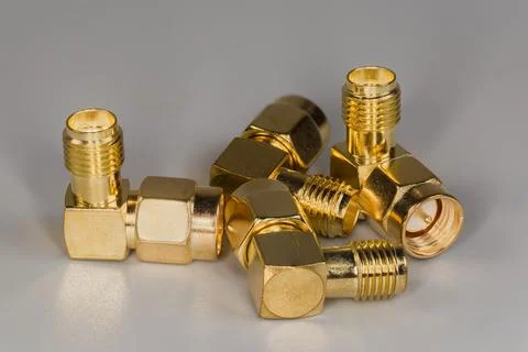 High-frequency yellow right angled coaxial adapters on gray surface Stock Photos