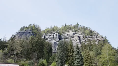 High gray rocks with green forest around on a sunny day Stock Footage 272772060