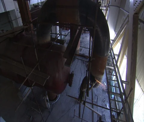 High hangle view of worker welding inside Shenhua Sanhe power station, tilt up. Stock-Footage 86746046