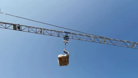 High Industrial Tower Crane Moving the Pallet with Building Materials Stock Footage 131553039