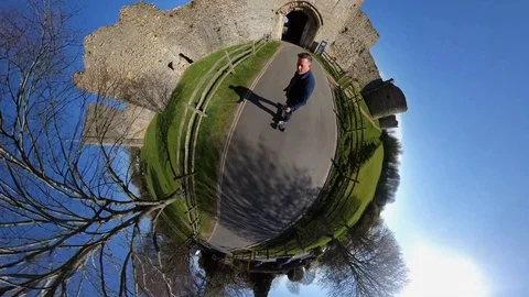 High level "tiny planet" shot of a man riding an electric skateboard along Video stock 107001967