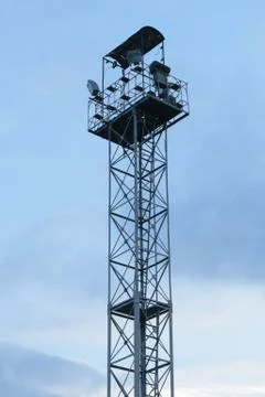 High lighting tower with observation platform at the top against a blue sky Stock Photos