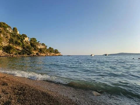 High limestone rocks emerging from clear blue sea at Cap d'Ail Fotos de archivo