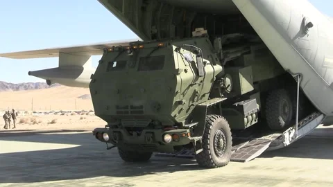 High Mobility Artillery Rocket System HIMARS reversing into C-130J Hercules Stock Footage 264755801