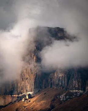 High mountain cliff with low clouds in Caucasus region in Russia Stock Photos