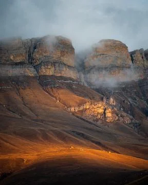 High mountain cliff with low clouds in Caucasus region in Russia Stock Photos