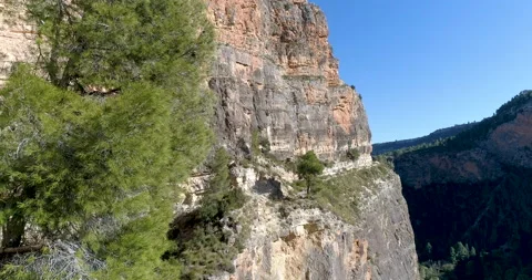 High mountain path suspended in a large vertical stone wall and flying drone Stock Footage 146965197