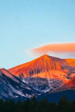 High mountains peak on the first rays of the sunrise, fresh morning. Sunset a Stock Photos