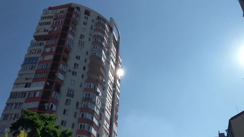 High multi-storey residental building, sunlight in a window. View from a stre Stock Footage 134290903