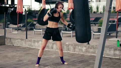 High pace video: Strong athletic female boxer in gloves exercising with a bag Stock Footage 80797950