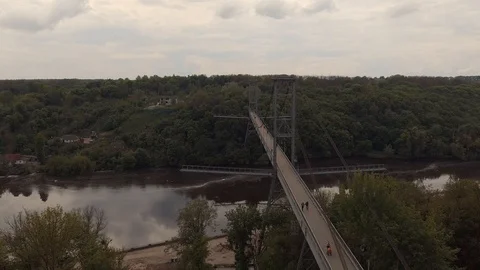 High pedestrian bridge on the cables across the river. Summer river landscape Stock Footage 112076344