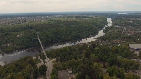 High pedestrian suspension cable bridge across the river. City aerial urban view Stock Footage 112076655