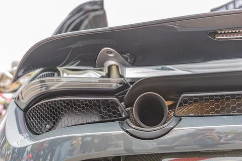 High-performance car exhaust system with hexagonal mesh and glossy carbon f.. 库存照片