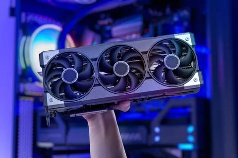 High performance graphics card held in hand with gaming pc background, mode.. Stock Photos