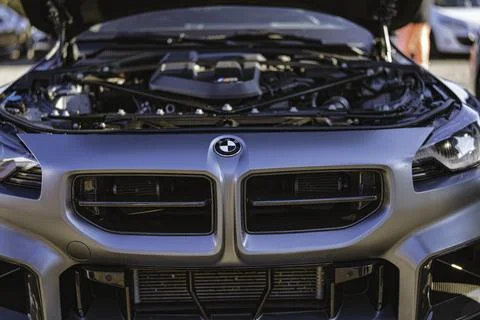 High performance gray bmw m sports car with open hood showing powerful engine Stock Photos