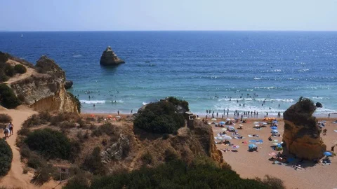 High perspective panning of beachgoers at Cova Redonda Beach in Algarve Stock Footage 115846062