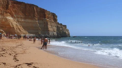 High perspective view of gold-coloured cliffs, busy beach and turquoise ocean in Stock-Footage 115937980