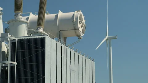 High potential power transformer against operating windmill Stock Footage 158425621