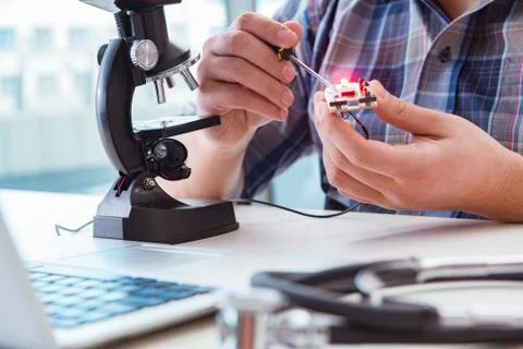 High precision engineering with man working with microscope Stock Photos
