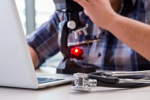 High precision engineering with man working with microscope Stock Photos
