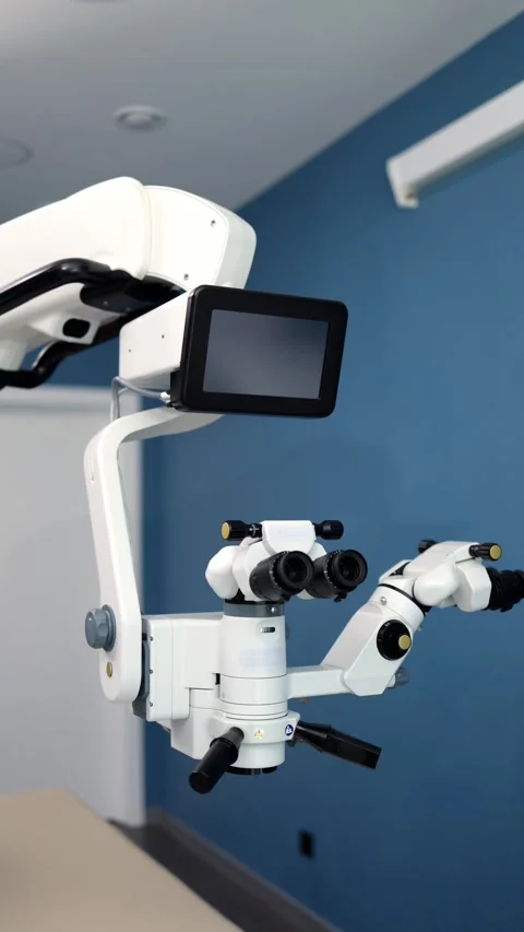 High-precision surgical microscope with dual eyepieces and monitor positioned in Stock Footage 337386179