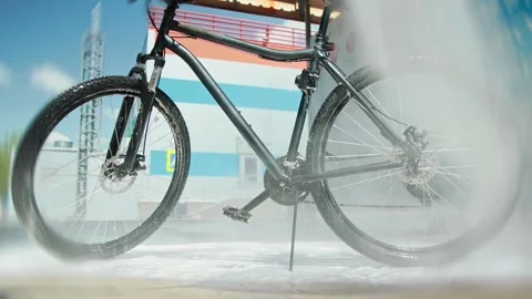 High-pressure rinse of bicycle by trigger gun at car wash. Cyclist washes off Stock Footage 296578691