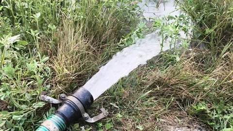 High-pressure water pump pipe irrigating a green agricultural field 動画素材 326290472