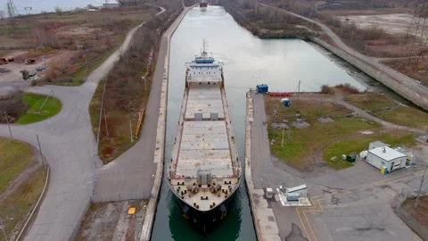 High quality, 4K aerial view of a bulk carrier ship maneuvering inside a canal. 動画素材 166063147