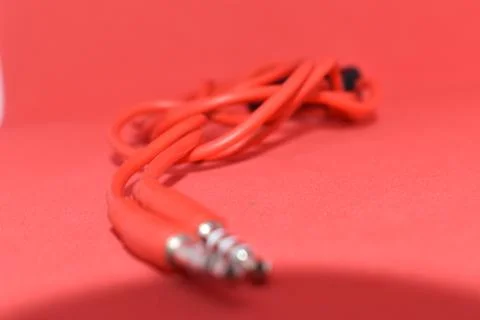 High-quality audio cable for display in red background. Stock Photos