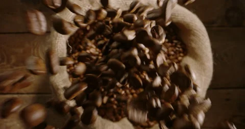 High quality fresh roasted coffee beans pour, falls in jute bag in close up Stock Footage 240833740