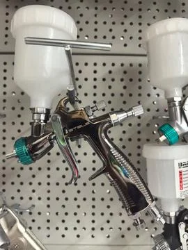 High-quality spray gun for precise painting tasks in a workshop setting Stock Photos