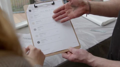 High Quality Video of a person browsing a Farrow and Ball color chart, flipping Stock Footage 321666191