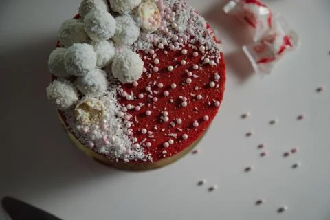 High red cake stands on a white table and piece of cake. Stock Photos