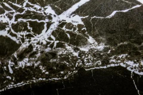 High-resolution close-up of black marble with sharp white veining and natural Stock Photos