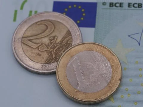 A high resolution image of a 1 and 2 euro coin on a 100 euro bill. Stock Photos