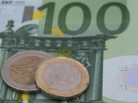 A high resolution image of a 1 and 2 euro coin on a 100 euro bill. Stock Photos