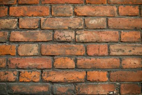 A high-resolution image of a rustic red brick wall. Stock Photos