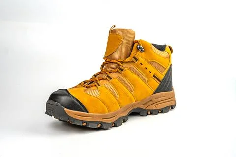 A high-resolution image of a single bright yellow hiking boot on a neutral .. Stock Photos