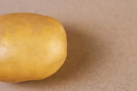 A high-resolution macro shot of a half golden potato segment resting Stock Photos