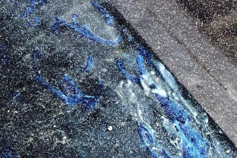 High-resolution macro texture of asphalt surface with embedded blue oil stains Stock Photos
