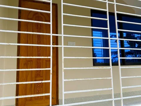 A high resolution photo shows a rustic white metal security bars exterior pro Foto stock