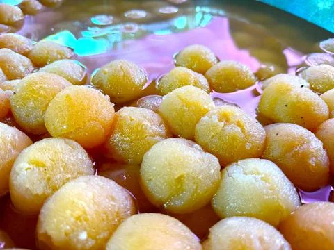 High resolution shows close up of soft golden dumplings soaking in sweet syru Foto stock